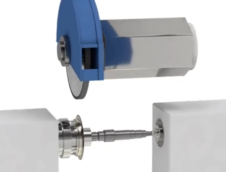 Industrial grinding wheel shaping a metal shaft