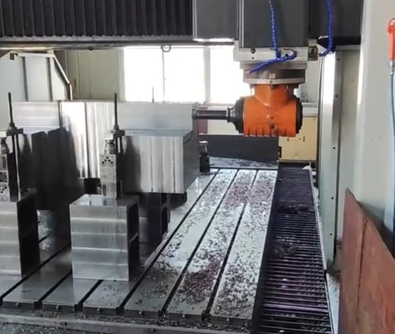 Large gantry CNC machine milling an oversized steel component in an industrial workshop