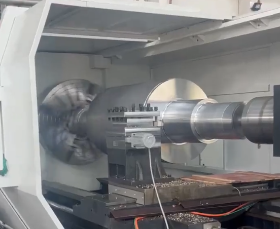 Operator monitoring 5-axis CNC machining of a large aluminum part
